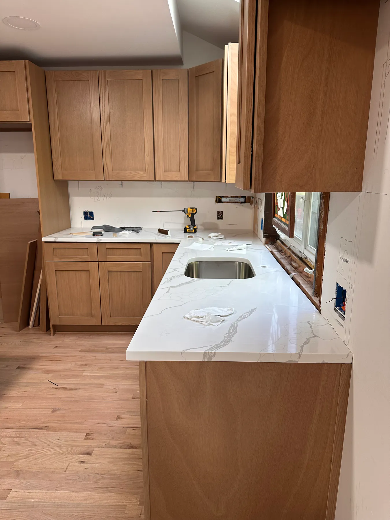 Quartz kitchen peninsula with an undermount stainless steel sink and a polished eased edge